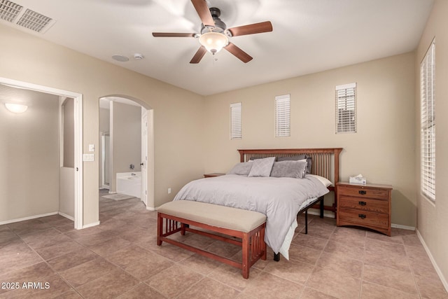 bedroom with arched walkways, ceiling fan, connected bathroom, visible vents, and baseboards