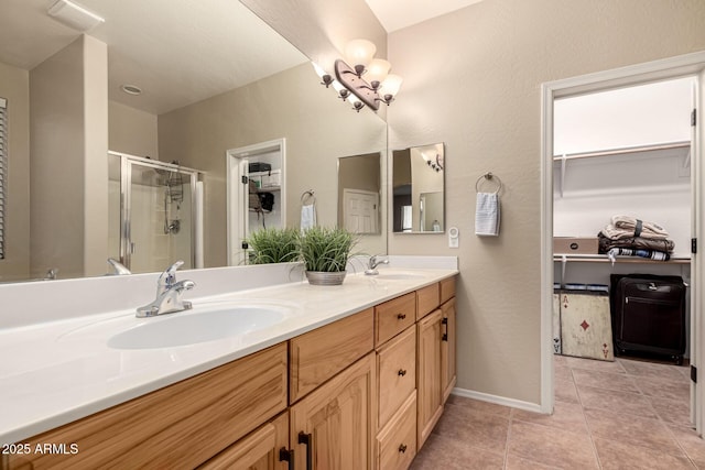 full bath with a stall shower, tile patterned flooring, a sink, and double vanity