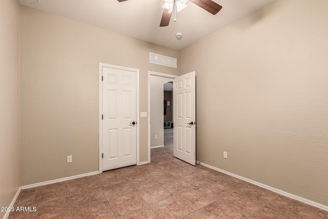 unfurnished bedroom with ceiling fan, light tile patterned floors, visible vents, and baseboards