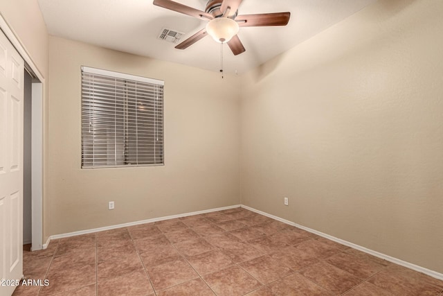 empty room with a ceiling fan, visible vents, and baseboards