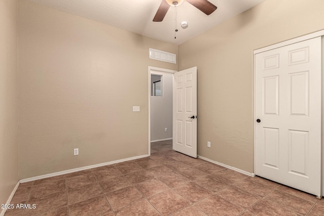 unfurnished bedroom featuring ceiling fan, visible vents, baseboards, and tile patterned floors