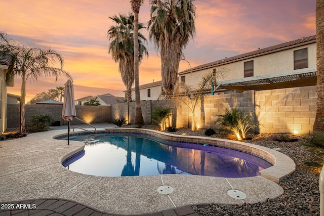 pool at dusk featuring a fenced in pool, a patio area, and a fenced backyard