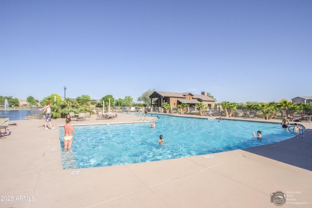 pool with a patio area and fence