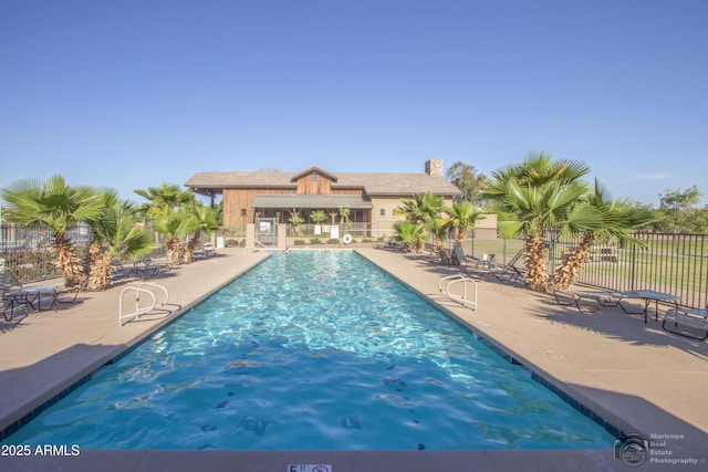 community pool with fence and a patio