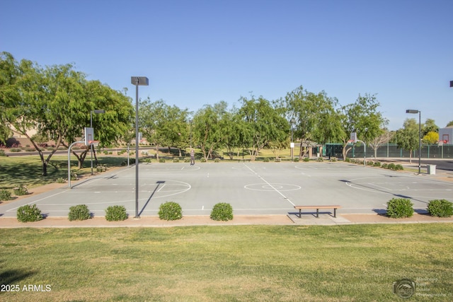 view of home's community featuring community basketball court, a yard, and fence