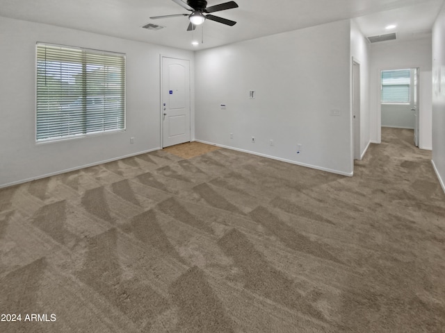 spare room featuring ceiling fan and light carpet