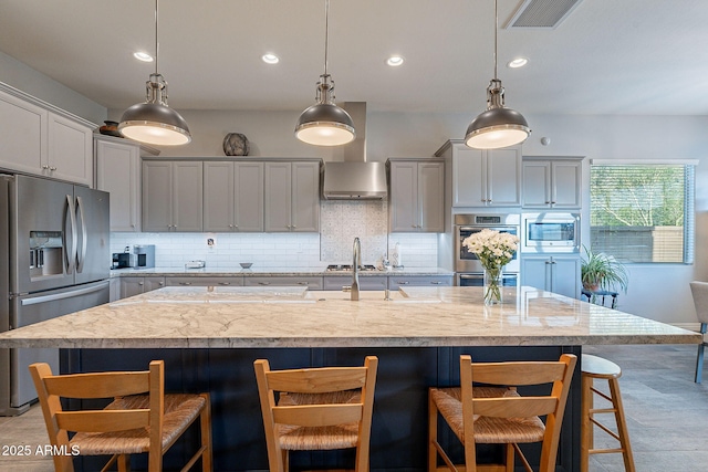 10207 W Hedge Hog Pl, Peoria, AZ 85383 - kitchen featuring appliances with stainless steel finishes, decorative backsplash, a breakfast bar area, recessed lighting, and hanging light fixtures