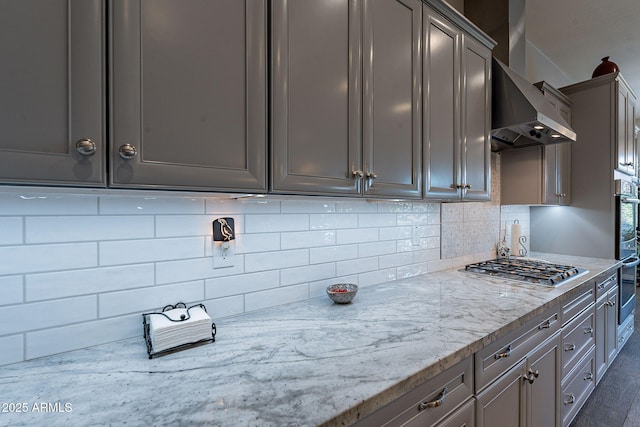 10207 W Hedge Hog Pl, Peoria, AZ 85383 - kitchen featuring wall chimney range hood, appliances with stainless steel finishes, backsplash, and light stone counters