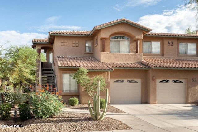 mediterranean / spanish house with stairway, stucco siding, driveway, and a garage