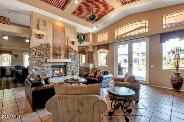 living room featuring high vaulted ceiling, french doors, a fireplace, and baseboards