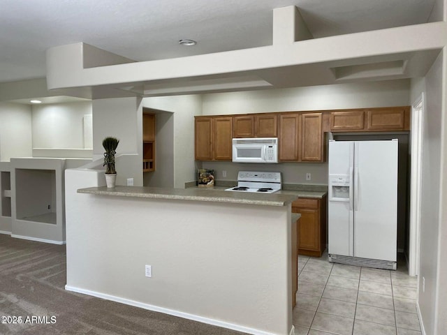 kitchen featuring brown cabinetry, white appliances, light countertops, and a peninsula