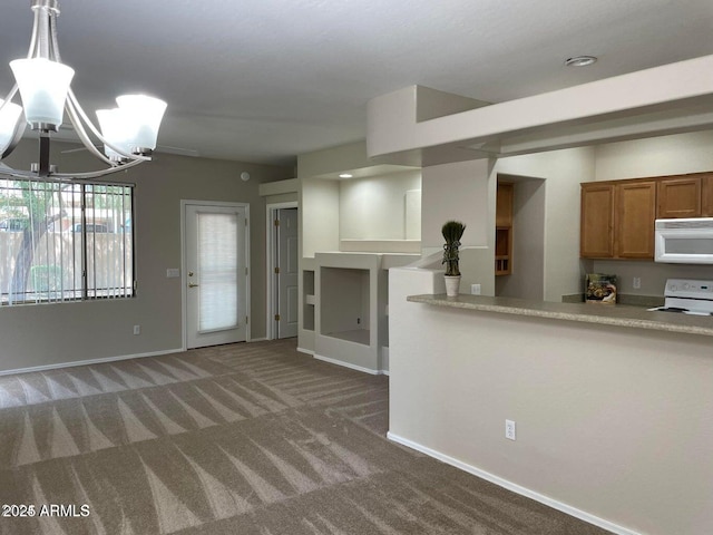 kitchen with baseboards, carpet flooring, brown cabinets, an inviting chandelier, and white appliances