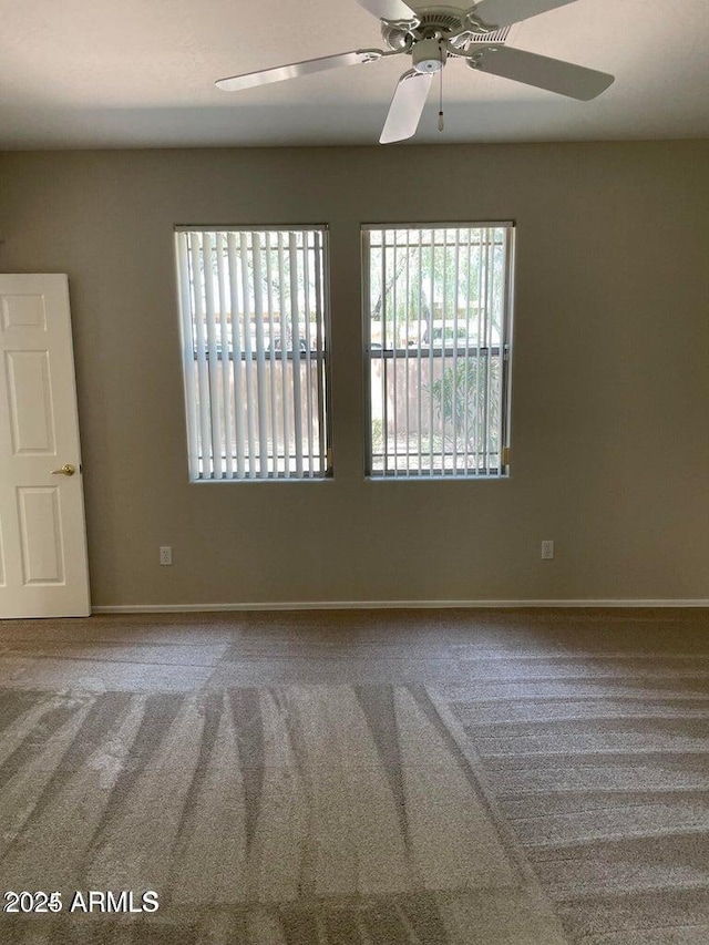 unfurnished room with baseboards, carpet, and a ceiling fan