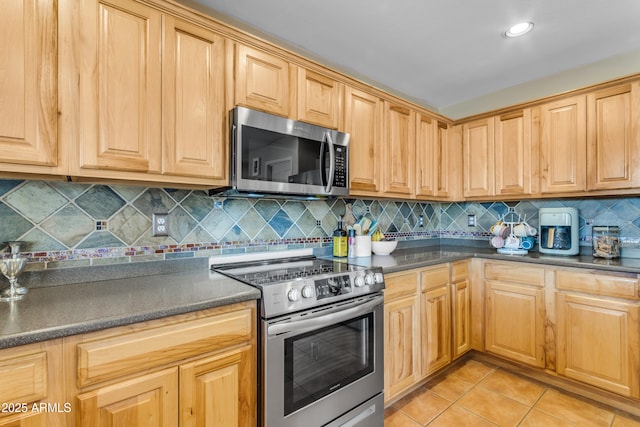 kitchen featuring light tile patterned floors, backsplash, and stainless steel appliances