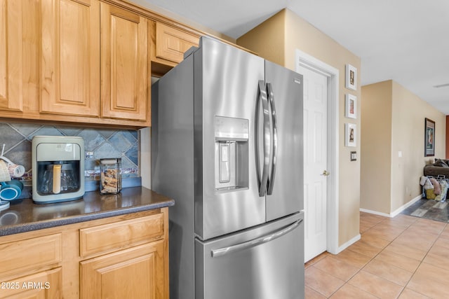 kitchen with stainless steel refrigerator with ice dispenser, light tile patterned flooring, and decorative backsplash