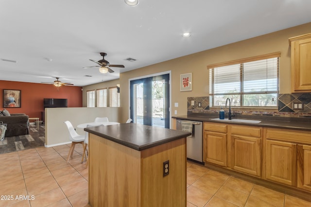 kitchen with sink, light tile patterned floors, stainless steel dishwasher, and a kitchen island