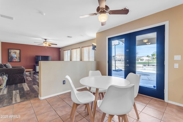 tiled dining room featuring french doors and ceiling fan