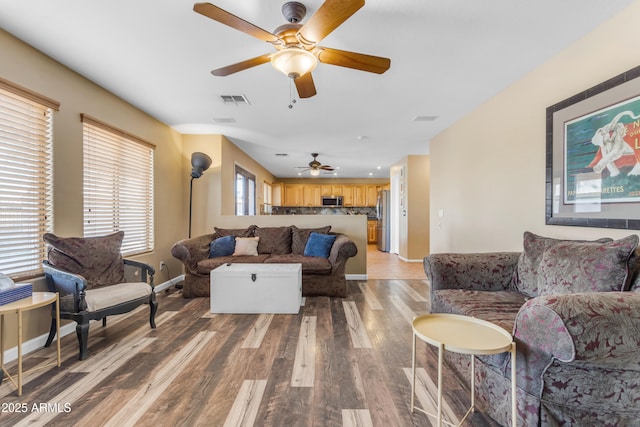 living room with ceiling fan and light hardwood / wood-style floors