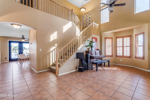 tiled foyer featuring ceiling fan and a high ceiling