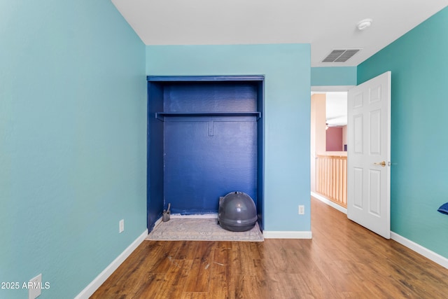 unfurnished bedroom featuring wood-type flooring and a closet