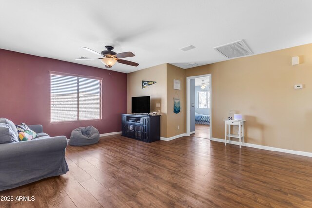 living room with dark hardwood / wood-style flooring and ceiling fan