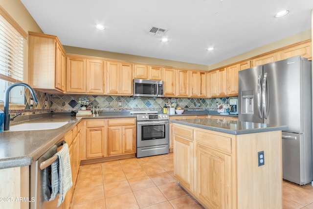 kitchen featuring sink, a center island, light tile patterned floors, appliances with stainless steel finishes, and decorative backsplash