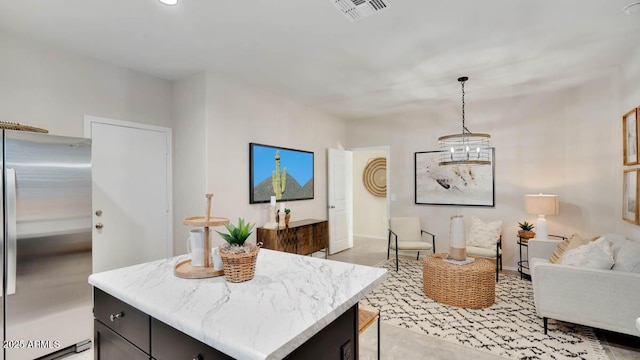 24052 W Pima St, Buckeye, AZ 85326 - kitchen featuring stainless steel fridge, a kitchen island, pendant lighting, open floor plan, and light stone countertops