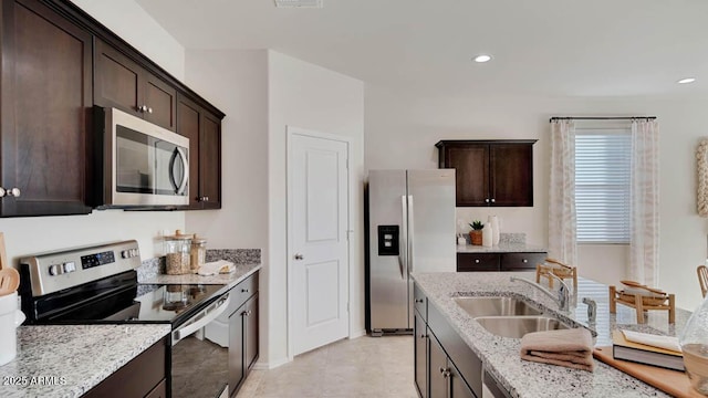 24052 W Pima St, Buckeye, AZ 85326 - kitchen with stainless steel appliances, dark brown cabinets, light stone countertops, and recessed lighting