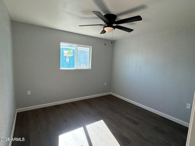 empty room with dark hardwood / wood-style floors and ceiling fan