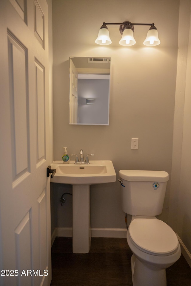 bathroom featuring sink, toilet, and hardwood / wood-style flooring