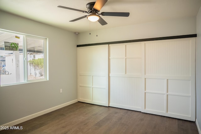 unfurnished bedroom with ceiling fan, wood-type flooring, and a closet