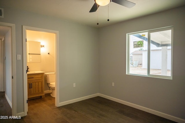 unfurnished bedroom with ceiling fan, ensuite bathroom, and dark hardwood / wood-style flooring