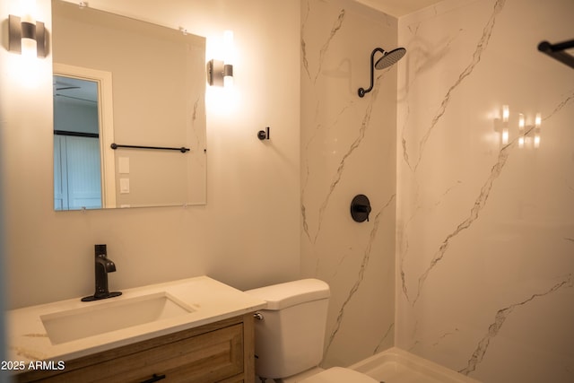 bathroom featuring a tile shower, toilet, and vanity