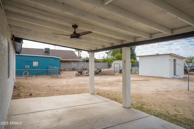 view of patio featuring ceiling fan and a shed