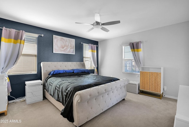 carpeted bedroom featuring baseboards and a ceiling fan