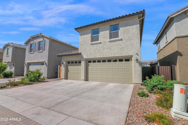 mediterranean / spanish-style house featuring stucco siding, driveway, an attached garage, and a tile roof