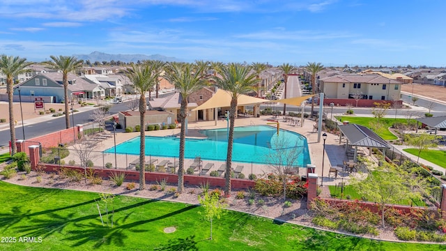 community pool featuring a patio area, a residential view, a lawn, and fence