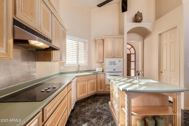 kitchen featuring sink, a high ceiling, white appliances, and light brown cabinetry