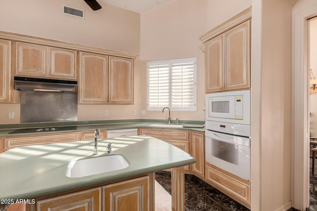 kitchen with white appliances, sink, and light brown cabinets