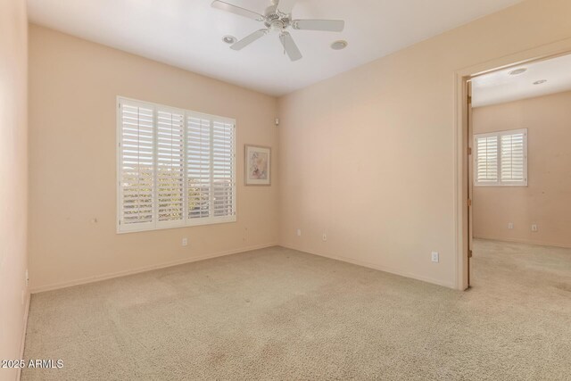 unfurnished room with ceiling fan and light colored carpet