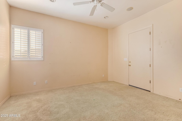 carpeted spare room featuring ceiling fan