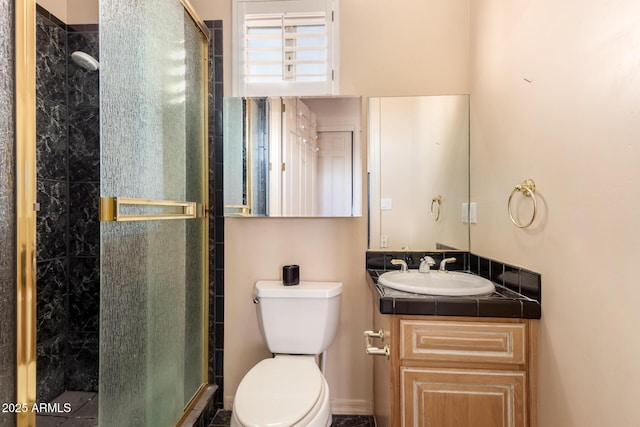 bathroom featuring toilet, a shower with door, and vanity