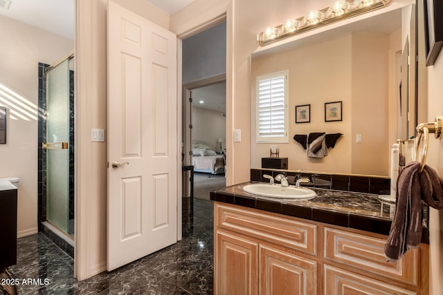 bathroom featuring a shower with door and vanity