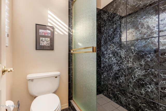 bathroom with toilet, a shower with shower door, and tile patterned floors