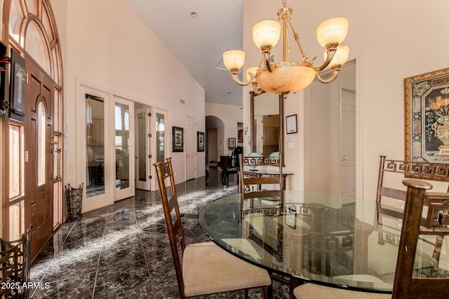 dining room with french doors, high vaulted ceiling, and an inviting chandelier