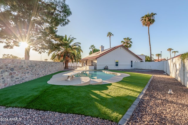 view of pool with a diving board and a yard