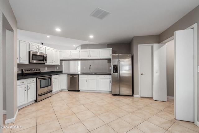 kitchen with white cabinets, light tile patterned floors, sink, and appliances with stainless steel finishes