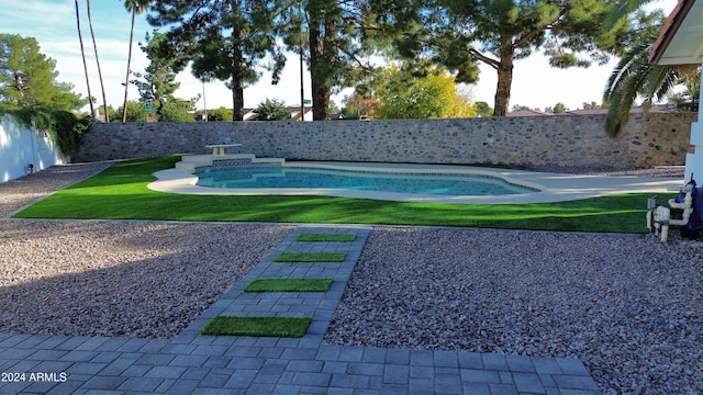 view of pool with a lawn