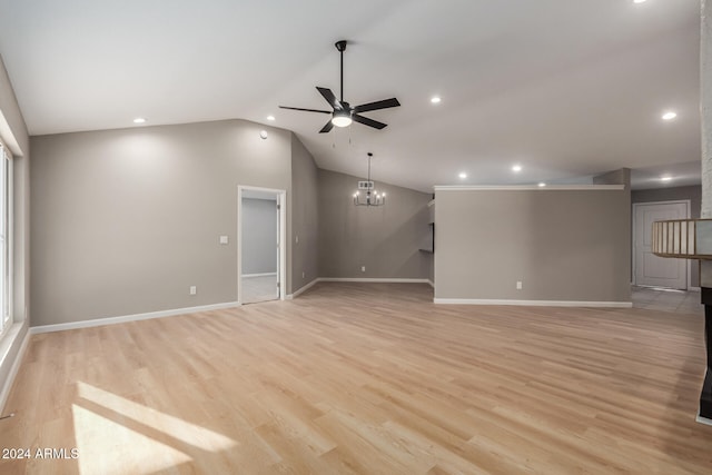 unfurnished living room with ceiling fan with notable chandelier, lofted ceiling, and light hardwood / wood-style flooring