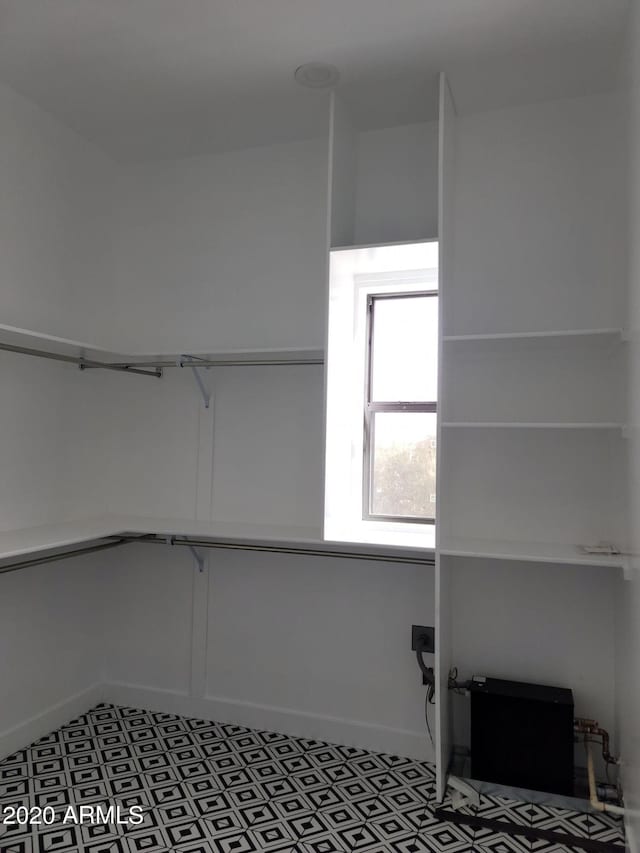 spacious closet featuring dark tile floors